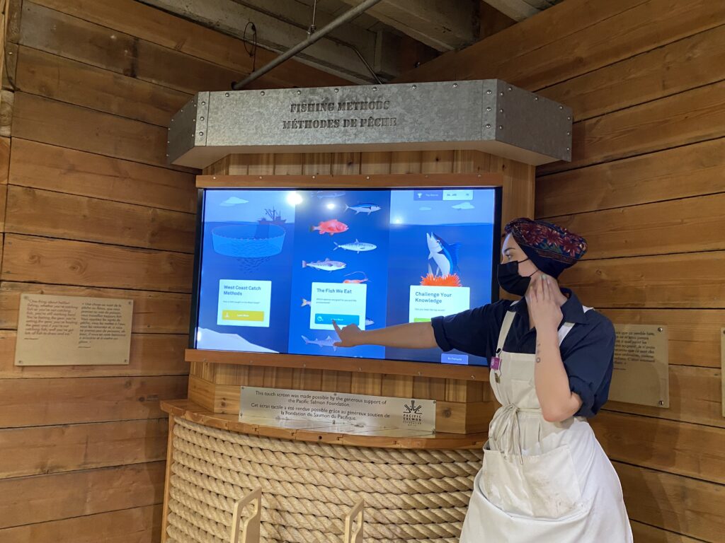 women posing by a large touchscreen tv