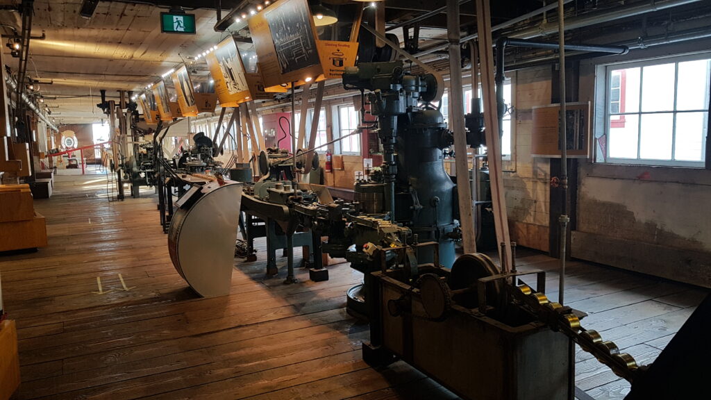 Long hallway with display of machinery and exhibit panels in a history museum